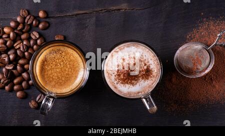 top view, close-up, on the dark wooden background, some types of espresso-based drinks, latte macchiato and cappuccino with a sprinkling of cocoa powd Stock Photo