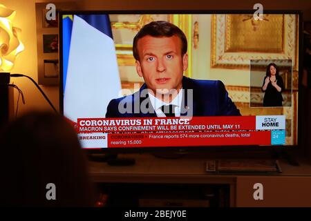 Pergine Valsugana, Italy. April 11, 2020: Coronavirus Pandemic - French President Emmanuel Macron address in Paris, France on April 13, 2020. A sweeping lockdown is in place in most part of Europe to try to slow down the spread of coronavirus pandemic. In Italy, at Pergine Valsugana a girl watch the France 24 TV Screen showing French President Emmanuel Macron address. In France Confinement will be at minimum till 11th of May 2020 and major public events will not be possible till mid July. (Photo by Pierre Teyssot/ESPA-Images) Stock Photo
