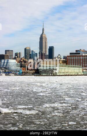 Iconic Empire State Building and Midtown Manhattan viewed over icy Hudson River in New York City, United States of America Stock Photo