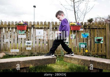 A child in the outside play area at a nursery school in Darlington, County Durham, UK. 18/4/2018. Photograph: Stuart Boulton. Stock Photo