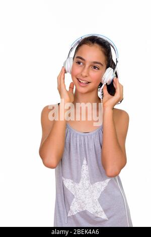 Studio shot of young happy teenage girl listening to music isolated against white background Stock Photo