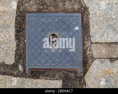 Square cast-iron lid, water register, in stone floor, Petropolis, Rio de Janeiro, Brazil Stock Photo