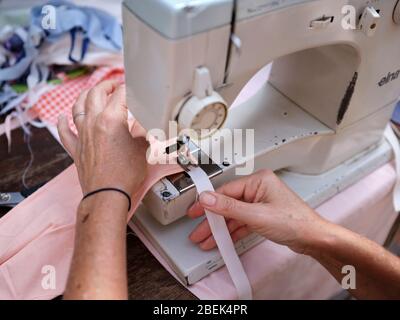 Woman making health masks during Covid-19 / Corona virus quarantine period 2020 in South Africa for distribution at an informal settlement. Stock Photo