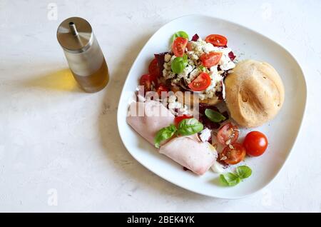 Food concept. Sandwich with cheese, ham, salad with tomatoes on white plate. White background. Top view. Stock Photo