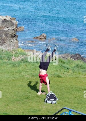 Newquay,Cornwall, 14th April 2020. UK weather: Sunshine and handstands during outdoor morning workout at Fistral Bay. Credit: Robert Taylor/Alamy Live News”