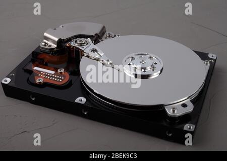 Disassembled computer hard drive with mirror disks on concrete background Stock Photo
