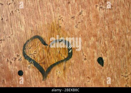 closeup view of heart shape draw by one kid with black paint in brown background door.Day time photography with Nikon camera on april 2020 Stock Photo