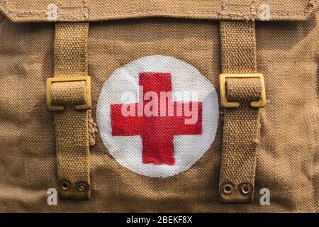 Red cross medical aid symbol on a vintage jute army bag Stock Photo