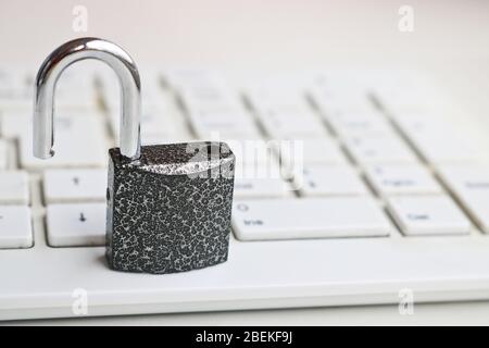 Selective focus Open lock on a white keyboard. Cybersecurity concept. Security Lock. Stock Photo