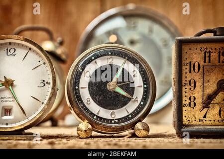 Retro styled image of old alarm clocks on a wooden table Stock Photo