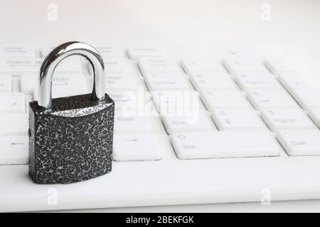 Selective focus Closed padlock on a white keyboard. Cybersecurity concept. Security Lock Stock Photo