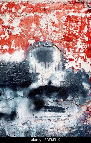 Peeled paint textured wall plaster surface with red and black paint. Grunge cracked wall texture background. Stock Photo