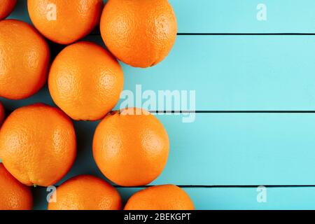 Pile of fresh oranges on blue wooden table with copy space. Top view. Stock Photo