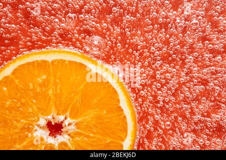 Orange fruit slice with bubbles. Orange soda drink beverage. Close up view. Stock Photo