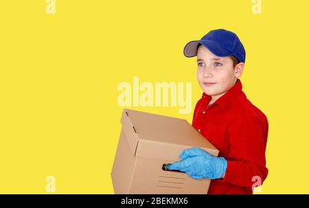 Delivery man employee in blue cap in gloves hold empty cardboard box Stock Photo