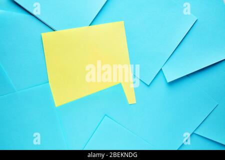 Blank yellow sticky sticker among blue note papers. Important message or reminder note with copy space Stock Photo