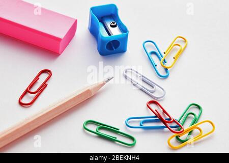 Stationery school supplies on white background. Pencil, sharpener, eraser and paper clips. Stock Photo