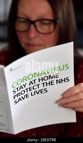 Woman reading coronavirus,covid-19 Government public information leaflet Stock Photo