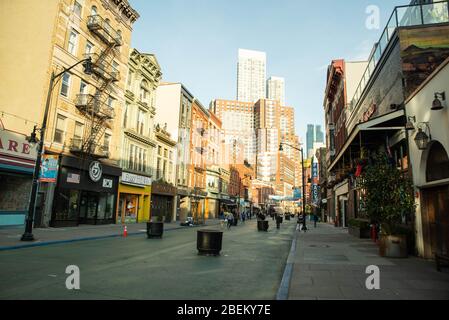 Jersey City, NJ - April 12 2020: Grove Street in NJ during the COVID-19 Outbreak. people are wearing masks.  Stock Photo