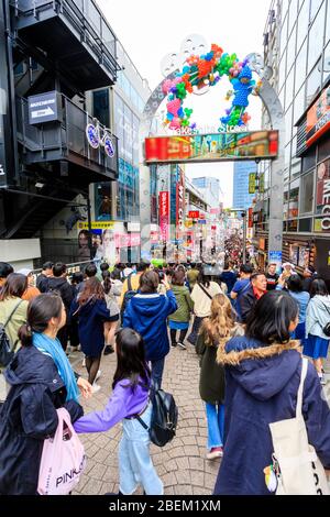 Takeshita Street entrance at Harajuku, Tokyo. View along he famous pedestrian shopping street crowded with Japanese and foreign tourists. Daytime. Stock Photo