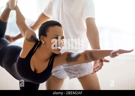 Woman practicing yoga with an instructor Stock Photo