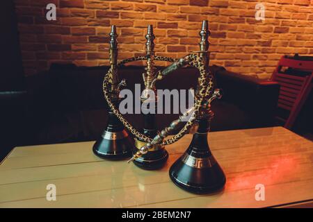 Stylish wooden hookah in the evening on a summer terrace in a cafe Stock Photo
