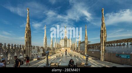 Milan, Italy - Aug 1, 2019: Numerous tourists walk on the observation deck on the roof of Milan Cathedral - Duomo di Milano, Lombardy, Italy. Stock Photo