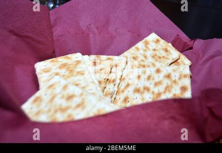Closeup of several saltine crackers in a basket lined with a dark red napkin, fresh saltines for a quick snack Stock Photo