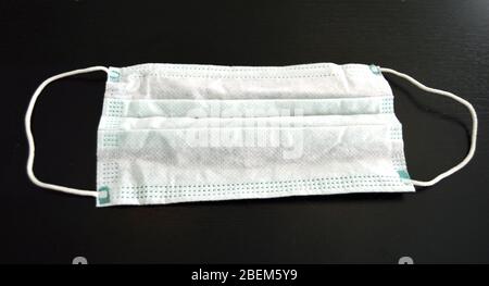 Medical face mask, closeup of a surgical mask on a dark background, virus protection during pandemic Stock Photo
