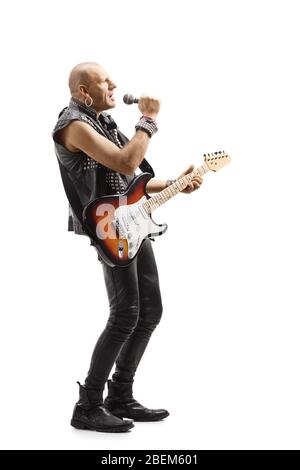 Full length profile shot of a male rock star with a microphone and an electric guitar isolated on white background Stock Photo