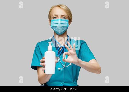 medical doctor nurse wearing protective mask - holding hand sanitizer spray or gel or liquid soap Stock Photo