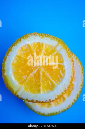 Macro shot of fresh orange slices on a blue background Stock Photo