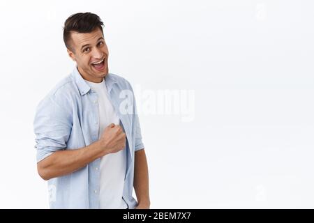 Portrait of luck upbeat handsome man, fist pump and smiling enthusiastic, encouraging team member making good job, praise nice work, delighted over Stock Photo