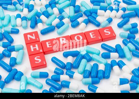 NHS Heroes letters tiles & assorted blue pills. For NHS in Covid 19 pandemic, NHS staff, NHS prescriptions, UK National Health Service, medicine in UK
