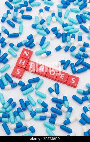 NHS Heroes letters tiles & assorted blue pills. For NHS in Covid 19 pandemic, NHS staff, NHS prescriptions, UK National Health Service, medicine in UK