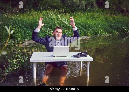 Frustrated depressed man holding head in hands shocked by bankruptcy stock downfall sitting at work desk with laptop, stressed tired businessman feels Stock Photo
