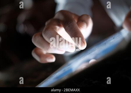 Close up of man hand using digital tablet at night. Stock Photo