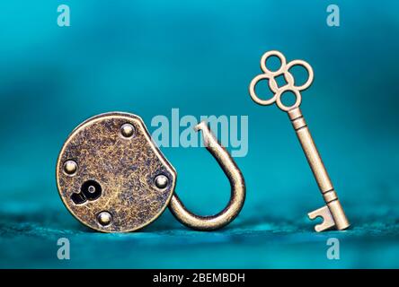 Success, solution, life coaching mentor concept. Key and unlocked padlock on blue background. Stock Photo