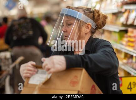 Doylestown, United States. 14th Apr, 2020. Employee Taffy Connolly loads a meat section as employees and customers follow safety protocols to help avoid coronavirus Tuesday, April 14, 2020 at ACME Market in Doylestown, Pennsylvania. Credit: William Thomas Cain/Alamy Live News Stock Photo