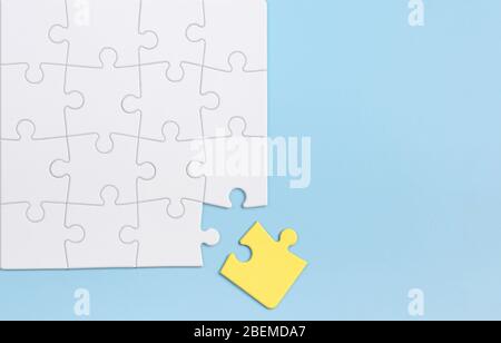 Out of the box thinking and individuality concept. Yellow puzzle against white ones on blue background. Stock Photo