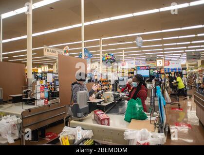 Doylestown, United States. 14th Apr, 2020. A shopper is checked out by cashier Leesaan Robertson as employees and customers follow safety protocols to help avoid coronavirus Tuesday, April 14, 2020 at ACME Market in Doylestown, Pennsylvania. Credit: William Thomas Cain/Alamy Live News Stock Photo