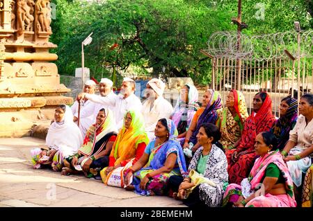 Village scene with older men and women from an indian village sitting cross legged on the ground in saree and kurta pyjama Stock Photo