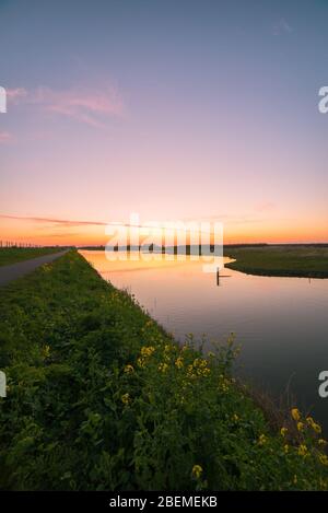 Tranquil scene of colorful sunset over water in recreation area Bentwoud, Netherlands Stock Photo