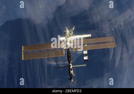 ISS - 16 October 2002 - Backdropped by a dark blue and white Earth, this full view of the International Space Station (ISS) was photographed by a crew Stock Photo