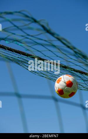 Football hitting the back of a goal net Stock Photo