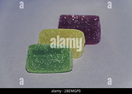 Three pieces of marmalade on a gray faded background Stock Photo