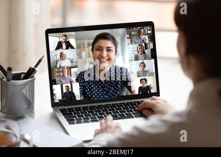 Indian lady lead videocall, pc screen view over woman shoulder Stock Photo
