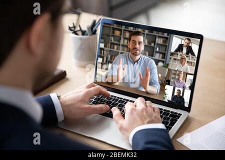 View over businessman shoulder laptop screen and videocall diverse participants Stock Photo