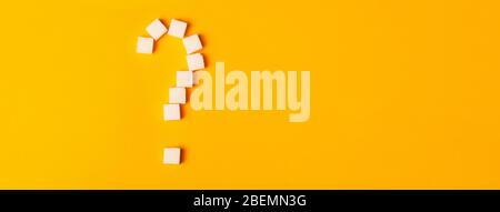 white sugar cubes shaped as a question mark on orange background. Top view. Diet unhealty sweet addiction concept Stock Photo