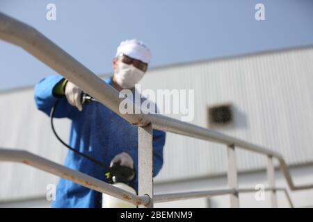 Manouba, Tunisia. 14th Apr, 2020. Cleaning worker disinfects the railing of the stairs on Apr. 14, 2020 in Industrial Zone Agba, Manouba, Tunisia. After the announcement of total containment throughout Tunisia on March 22, 2020, factories and viral sectors are continuing their activities while respecting the precautions against the pandemic of CoViD-19. This story follows the daily routine of workers at Marquardt Tunisia automotive factory in Manouba, Tunisia during the Covid-19 coronavirus pandemic. (Photo by Mohamed Krit/Sipa USA) Credit: Sipa USA/Alamy Live News Stock Photo